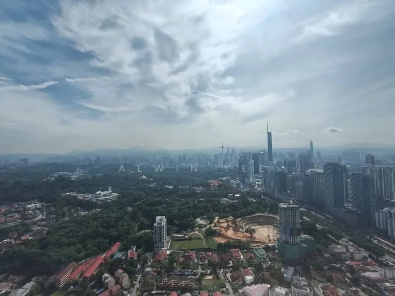 Exterior type: high-rise condominium; features: city skyline view, surrounded by greenery, construction site visible, urban landscape, high-rise buildings, distant mountains; style: modern.