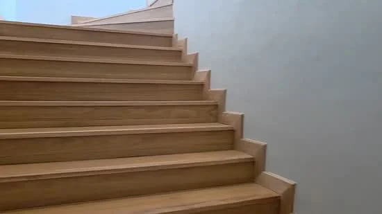 Room features: wooden staircase, light wood finish, straight staircase design, smooth handrail, neutral wall color, natural light from above; style: modern.