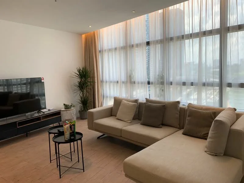 Living features: L-shape sectional sofa in beige, decorative cushions, black coffee table, wall-mounted TV, floor-to-ceiling windows, sheer curtains, wooden flooring, indoor plant, light fixtures, neutral wall colour; style: modern; view: city.