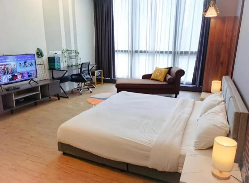 Bedroom features: king-size bed with white bedding, wooden flooring, floor-to-ceiling windows with sheer curtains, wall-mounted TV, wooden accent wall behind bed, upholstered armchair in brown, desk with ergonomic chair, table lamp on bedside table, decorative throw pillow on armchair, open shelving unit, plant on shelf; style: modern; view: city.