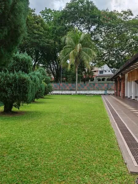 Exterior type: landscape garden; features: manicured lawn, mature trees, paved walkway, fenced perimeter, tropical landscaping; style: tropical-modern.