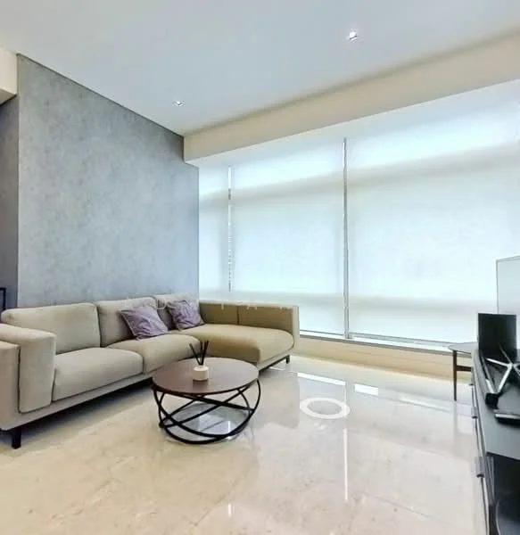 Living features: beige fabric sofa, round coffee table with black metal base, grey accent wall, large windows with sheer roller blinds, marble flooring, recessed downlights, decorative plant on coffee table, two purple throw pillows; style: modern.