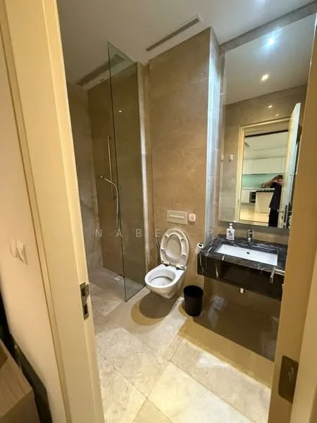 Bathroom features: glass shower enclosure, rain shower head, wall-mounted faucet, single-sink vanity with dark countertop, framed mirror, one-piece toilet, tile flooring, beige wall tiles, recessed lighting; style: modern.