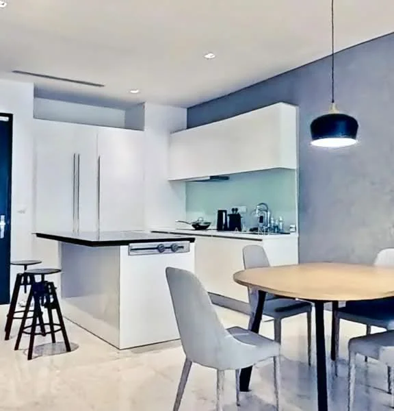 Kitchen features: white cabinetry, black countertop, stainless-steel refrigerator, built-in oven, single-bowl stainless-steel sink, chrome pull-down faucet, pendant light, marble tile flooring, grey accent wall, round dining table, 4 dining chairs, bar stools; style: modern.