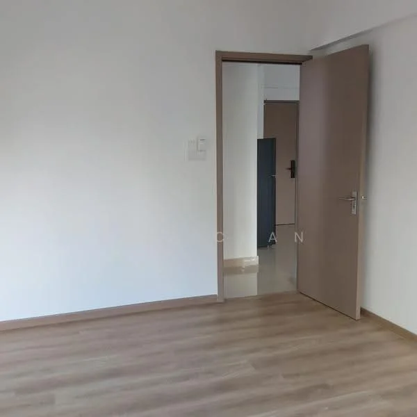 Room features: light wood laminate flooring, white painted walls, single wooden door, door frame, neutral color scheme, no visible furniture, natural light from doorway, minimalist decor; style: modern.