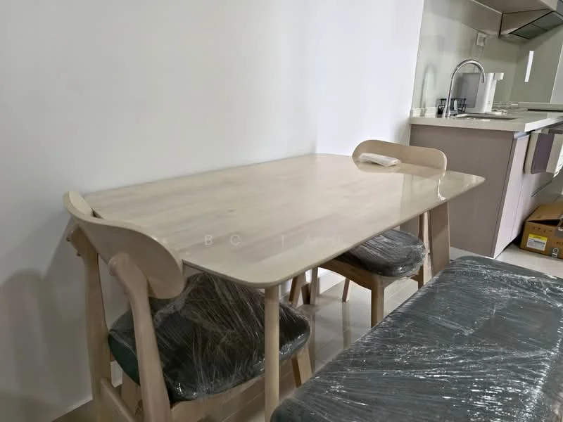 Dining features: light wood dining table, 4 dining chairs with green cushions, plastic wrap on chairs, neutral wall color, flooring visible, kitchen area in background; style: modern.