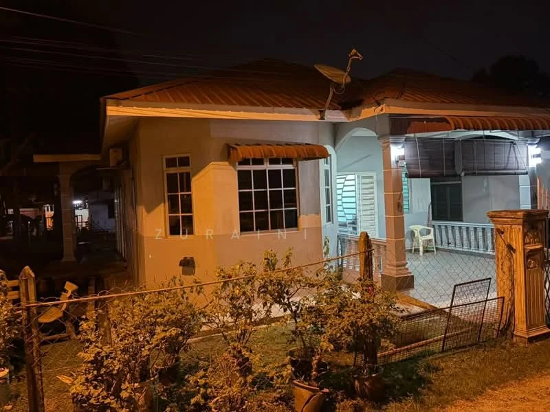Exterior type: detached bungalow; features: single-storey, red tiled roof, cream painted facade, front porch with seating, garden area with shrubs, fenced yard, outdoor lighting, satellite dish on roof; style: traditional.