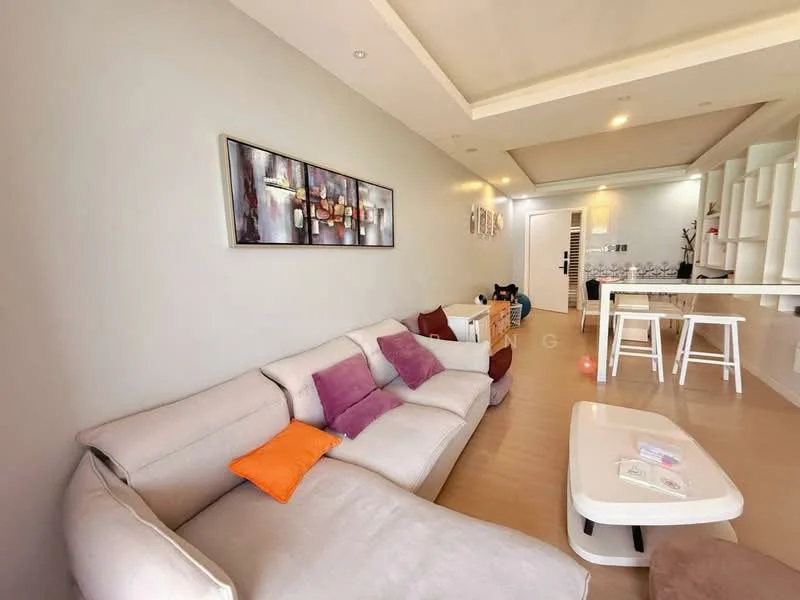 Living features: L-shape sectional sofa in light grey, decorative cushions in purple and orange, coffee table in white, wall-mounted artwork with abstract design, recessed ceiling with downlights, light wood flooring, open layout to dining area, built-in shelving unit, neutral painted walls; style: modern.