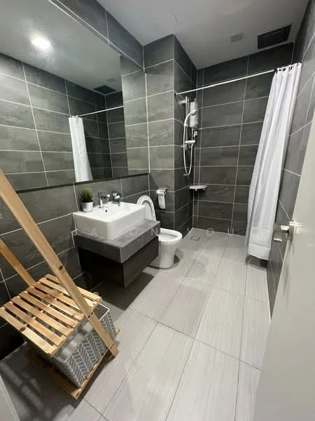 Bathroom features: grey tiled walls, light grey tiled flooring, single-sink vanity with wood cabinet, chrome basin mixer faucet, framed mirror, one-piece toilet, walk-in shower with glass enclosure, shower head with adjustable height, white shower curtain, wooden ladder shelf, decorative plant, toilet paper holder; style: modern.