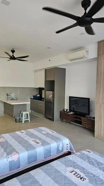 Room features: 2 single beds with grey patterned bedding, 2 ceiling fans, wall-mounted TV, wooden TV console, stainless-steel fridge, kitchenette with grey cabinetry, white tiled backsplash, countertop with sink, open layout, light-colored flooring, air conditioning unit; style: modern.