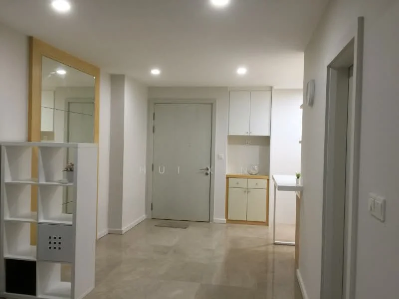 Room features: white painted walls, light grey tiled flooring, recessed LED downlights, mirror with wooden frame, white cabinetry with wooden accents, door with metal handle, open shelving unit, countertop, wall-mounted light switch; style: modern.