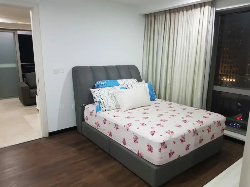Bedroom features: queen-size bed with grey upholstered headboard, floral-patterned bedspread, wooden flooring, floor-to-ceiling windows, sheer curtains, decorative pillows, nightstand with lamp, wall-mounted artwork; style: modern; view: city. Room features: sofa in living area visible through doorway, neutral wall color, recessed lighting.