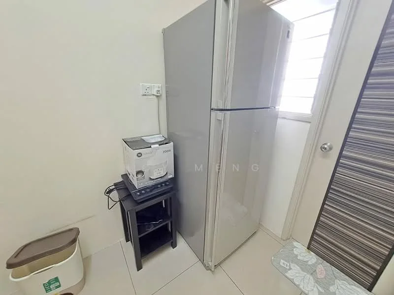 Kitchen features: stainless-steel fridge, white rice cooker, black side table, cream tiled flooring, white walls, window with horizontal slats, door with wood grain pattern, small mat on floor.
