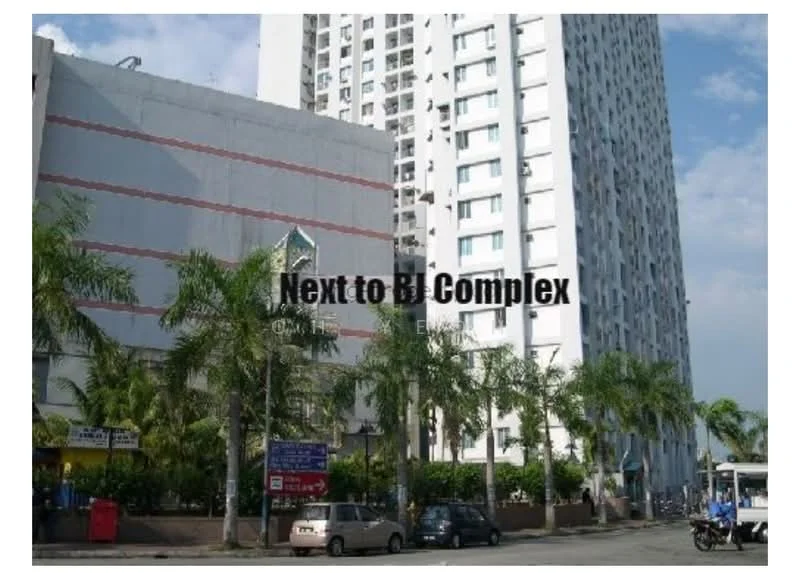 Exterior type: high-rise condominium; features: white painted facade, red accent stripes, tall residential building, palm trees in foreground, manicured landscaping, parking area visible, adjacent to BI Complex; style: modern.