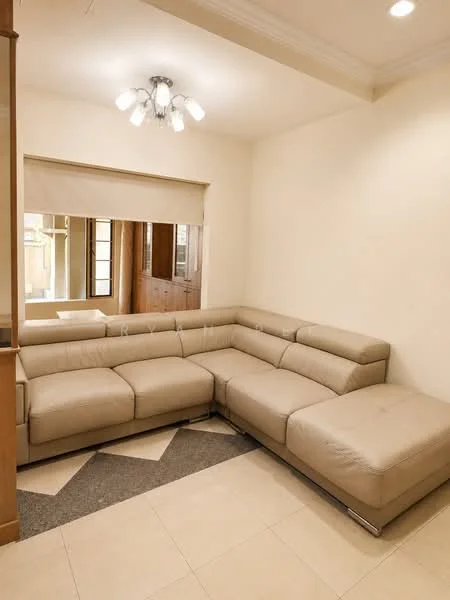 Living features: L-shape sectional sofa in beige leather, chandelier with multiple bulbs, cream painted walls, tile flooring in light beige, large mirror on wall, window with sheer blinds, crown moulding on ceiling, open layout to adjacent room; style: modern.