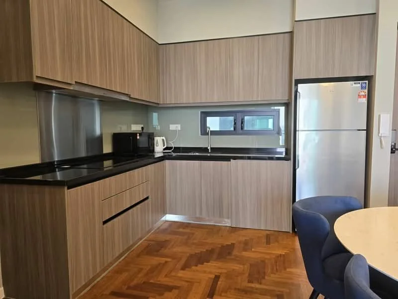 Kitchen features: brown wooden cabinetry, black granite countertop, stainless-steel fridge, built-in microwave, black sink, chrome faucet, kettle, wooden flooring with herringbone pattern, two windows, white walls; style: modern.
