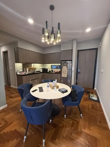 Dining features: round dining table, 4 upholstered dining chairs in blue, wooden flooring with herringbone pattern, pendant light fixture with multiple bulbs, kitchen cabinetry in dark wood, countertop with under-cabinet lighting, refrigerator, microwave, kettle, wall-mounted door, decorative wall paneling, open space layout; style: modern.