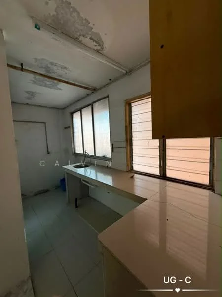 Kitchen features: white tiled flooring, white walls with peeling paint, large windows with horizontal slats, single countertop with a smooth surface, built-in cabinetry, sink area, exposed plumbing, light fixture on ceiling.