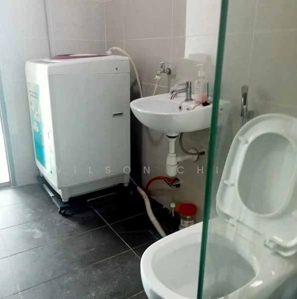 Bathroom features: white ceramic toilet, single-sink vanity with chrome faucet, washing machine, grey tiled flooring, light grey wall tiles, glass shower enclosure, plumbing visible, soap dispenser, toilet paper holder; style: modern.