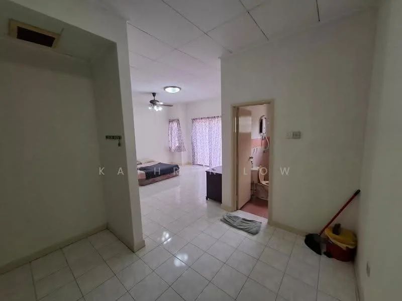 Room features: white painted walls, white tiled flooring, ceiling fan, window with sheer curtains, doorway leading to another room, bathroom door visible, cleaning supplies visible, natural light from window.