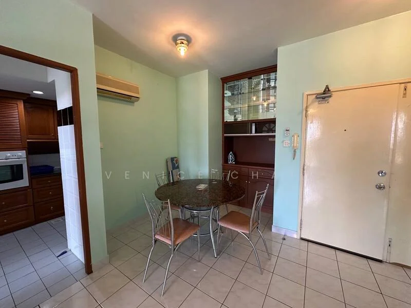 Dining features: round dining table, 4 dining chairs, green painted walls, tile flooring, wall-mounted air conditioning unit, built-in shelving unit, door leading to hallway, light fixture on ceiling. Room features: white door, kitchen area visible in background.