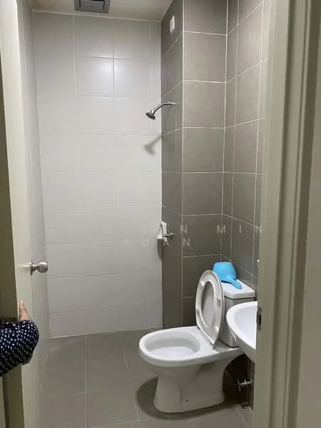 Bathroom features: grey tiled walls, white ceramic toilet, chrome shower head, shower with wall-mounted faucet, grey tiled flooring, white sink, mirror above sink, toilet paper holder; style: modern.