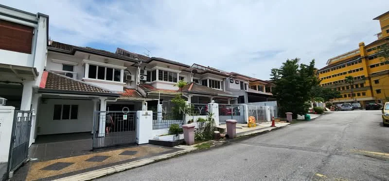 Exterior type: linked terrace house; features: two-storey linked terrace, white painted facade, red tiled roof, front garden with landscaping, metal gate, driveway with interlocking pavers, visible air conditioning units, manicured lawn, surrounded by mature trees, parking spaces visible, adjacent to a main road; style: modern.