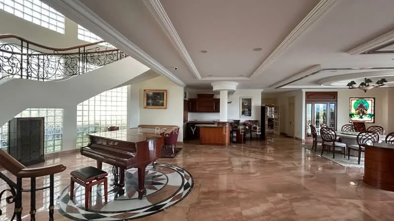 Living features: marble flooring, tray ceiling, chandelier, large windows with natural light, stained glass window, piano, open layout to kitchen and dining area, decorative wall art, wooden staircase, railings with intricate design; style: luxury; view: garden. Kitchen features: wood cabinetry, granite countertop, built-in oven, stainless-steel fridge, kitchen island, open layout to living area; style: luxury; view: garden. Dining features: round dining table, upholstered dining chairs, decorative centerpiece, open layout to living area; style: luxury; view: garden.