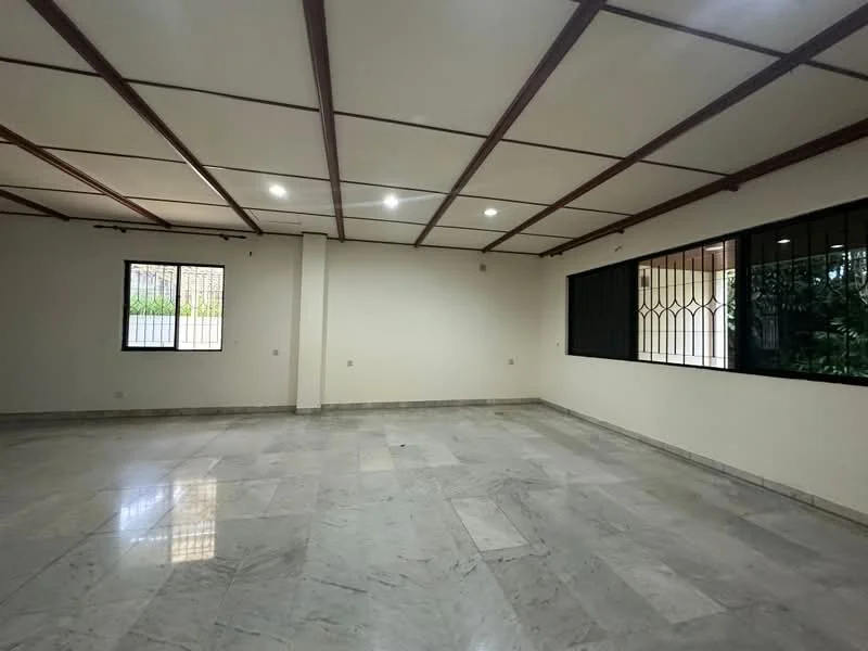 Room features: marble flooring, white painted walls, exposed ceiling beams, recessed LED downlights, large windows, security bars on windows, natural light, spacious layout; style: modern; view: garden.