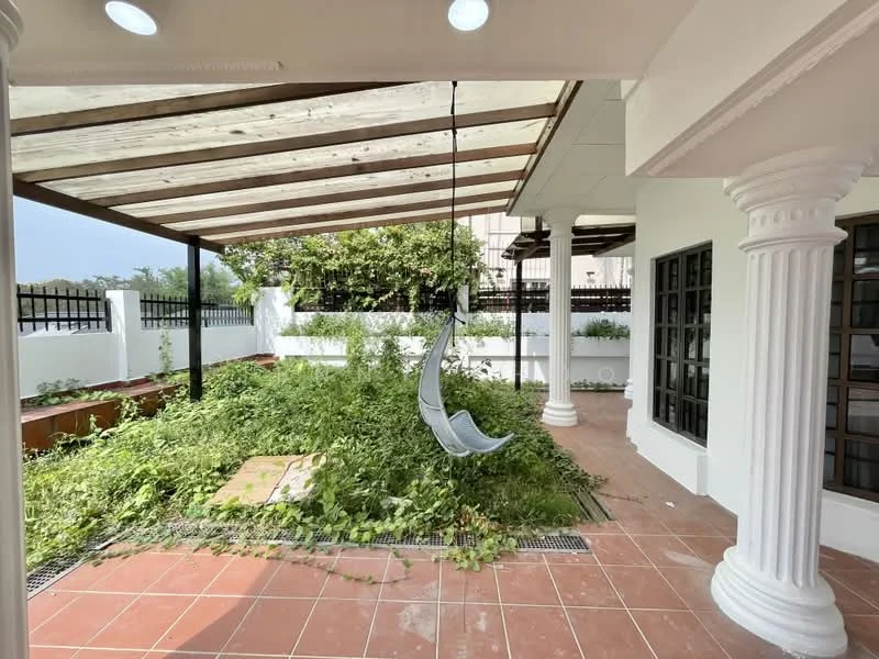 Exterior type: detached bungalow; features: covered patio with wooden beams, hanging swing chair, terracotta tile flooring, manicured garden area, white painted walls, decorative columns, greenery surrounding the patio, fenced perimeter; style: modern.