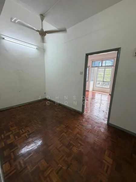 Room features: wooden flooring, white painted walls, ceiling fan, doorway leading to another room, window with metal grille, light fixture on ceiling, baseboard, neutral color scheme.