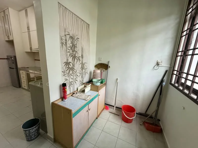 Laundry features: white walls, tile flooring, window with metal grille, wooden cabinet with countertop, sink, broom, mop, red bucket, grey bucket, wall-mounted electrical outlet.