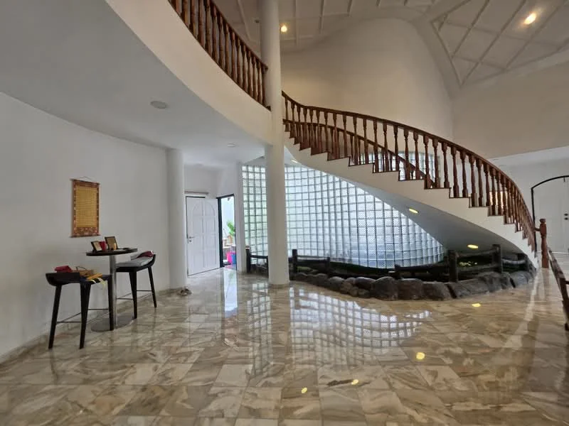 Room features: marble flooring, white painted walls, high ceiling with exposed beams, spiral wooden staircase, glass block wall, decorative stone feature, open layout, natural light from large windows, entrance door, table with chairs; style: modern; view: garden.