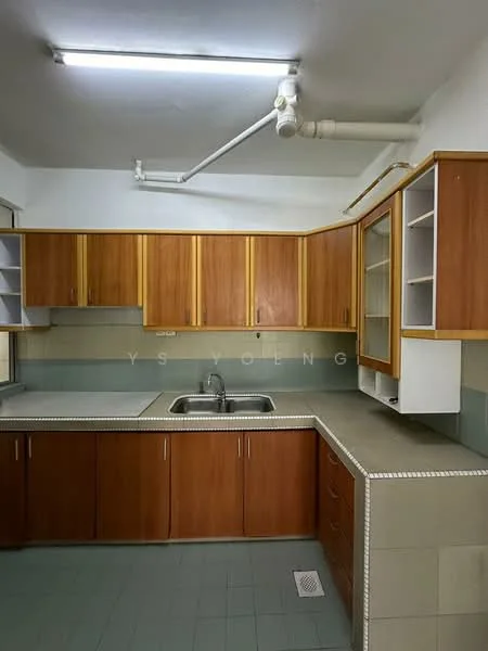 Kitchen features: wooden cabinetry in light brown, double-bowl stainless-steel sink, chrome faucet, grey countertop, green tiled backsplash, wall-mounted cabinets, open shelving, floor tiles in light green, fluorescent ceiling lights, plumbing pipes visible on ceiling.