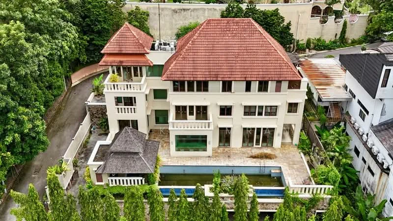 Exterior type: detached bungalow; features: red pitched tile roof, white painted facade, large windows, balconies on upper floors, swimming pool, stone-paved pool deck, manicured landscaping, surrounded by greenery, two-storey structure, outdoor seating area, driveway leading to the entrance; style: modern.
