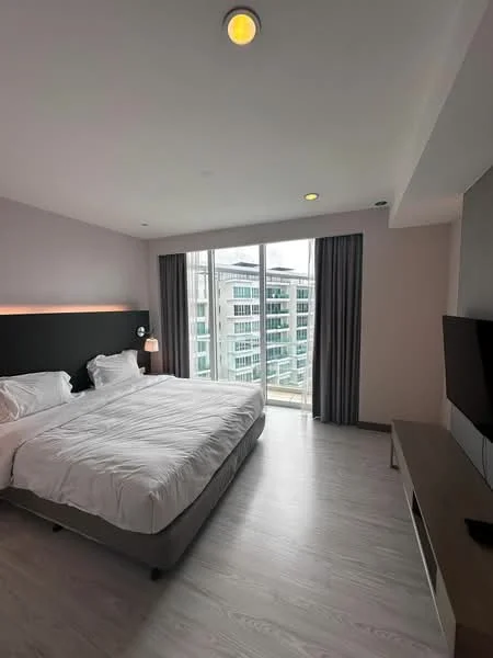 Bedroom features: king-size bed with white bedding, upholstered headboard, two bedside lamps, floor-to-ceiling windows, curtains, wooden flooring, wall-mounted TV, TV console, recessed ceiling lights; style: modern; view: city.