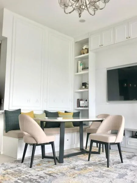 Dining features: rectangular dining table with black legs, 4 beige upholstered dining chairs, built-in bench seating with cushions, white cabinetry with open shelving, decorative items on shelves, wall-mounted TV, chandelier light fixture, area rug with geometric pattern, neutral wall colour, crown moulding on ceiling; style: modern.