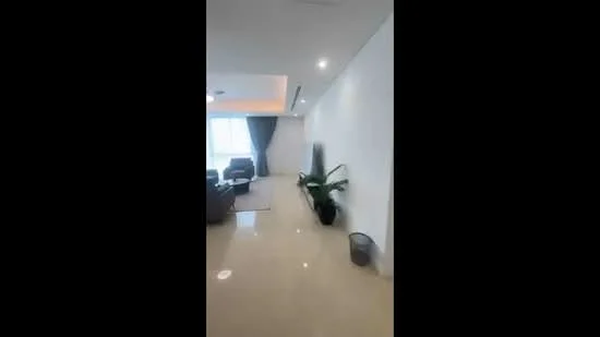 Room features: cream painted walls, recessed downlights, floor-to-ceiling windows, grey curtains, polished tile flooring, indoor plant, decorative wall feature, open space layout; style: modern; view: city.