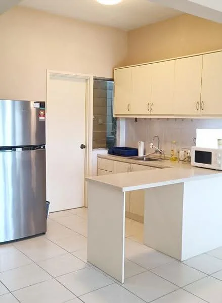 Kitchen features: stainless-steel fridge, single-bowl stainless-steel sink, chrome pull-down faucet, laminate countertop, white cabinetry, built-in microwave, ceramic tile flooring, light fixture on ceiling, neutral painted walls, open layout with island, window with sheer curtains; style: modern.