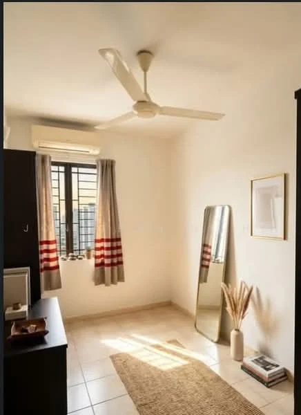 Room features: cream painted walls, tile flooring, 5-blade ceiling fan, wall-mounted split AC, floor-to-ceiling window, sheer curtains, full-length mirror, decorative vase with dried plants, area rug, wooden cabinet, small side table, framed artwork; style: modern; view: city.