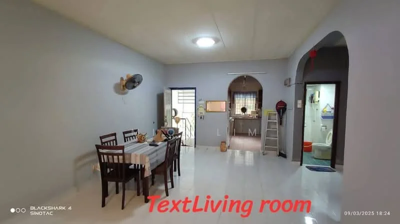 Living features: white painted walls, polished tile flooring, ceiling light fixture, wall-mounted fan, dining table with four chairs, tablecloth on dining table, open layout, arched doorway to kitchen, window with security grille, door leading outside, decorative wall clock; style: modern. Kitchen features: white painted walls, tile flooring, kitchen counter with sink, wall-mounted cabinets, stove, refrigerator, open layout, door leading to bathroom, window; style: modern.