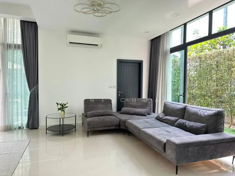 Living features: grey L-shape sectional sofa, round glass coffee table, floor-to-ceiling windows, sheer curtains, white painted walls, recessed downlights, 1 wall-mounted split AC, tile flooring, decorative indoor plant, sliding glass door, greenery view; style: modern; view: garden.