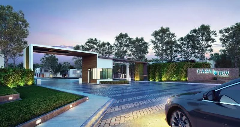 Exterior type: main entrance gate; features: modern architectural design, landscaped greenery, paved driveway, illuminated pathway, signage with 'CASA VIEW', glass entrance structure, wooden accents, surrounding trees, open-air canopy, security booth, parking area, decorative stone wall; style: modern.