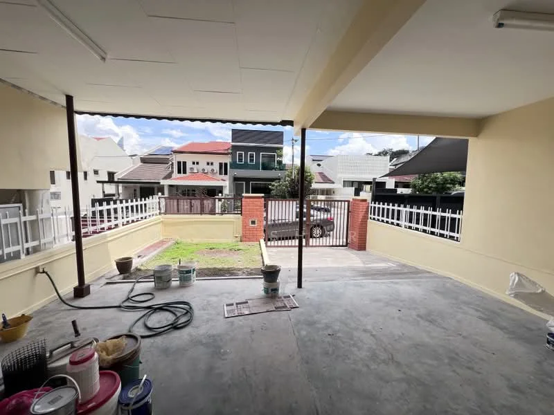 Exterior features: concrete flooring, covered porch area, fenced yard, manicured lawn area, paint buckets and tools visible, partially enclosed space, metal railing, open view of surrounding houses.
