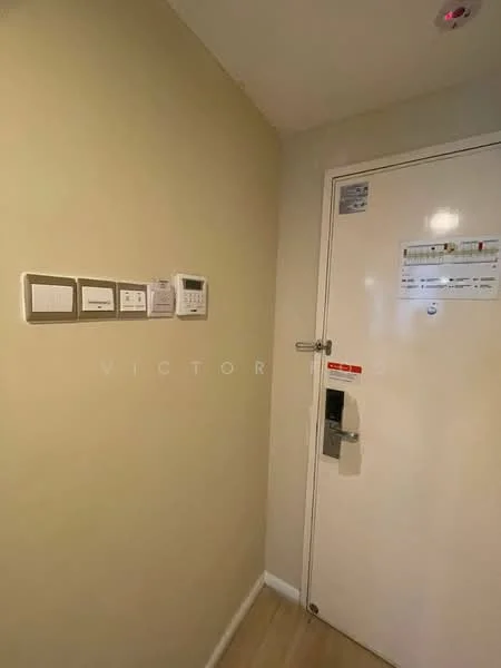 Room features: light beige painted walls, wooden flooring, electrical switches, thermostat, security intercom, door with electronic lock, door viewer, door handle; style: modern.