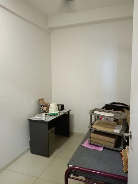 Room features: white painted walls, tile flooring, desk with black surface, kettle, stack of boxes, bed with grey bedding, small table, light source from ceiling.