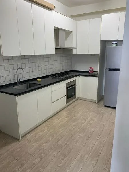 Kitchen features: white cabinetry, black countertop, stainless-steel sink, chrome pull-down faucet, 4-burner gas hob, built-in oven, fridge, white tiled backsplash, laminate flooring, wall-mounted cabinets, under-cabinet lighting; style: modern.