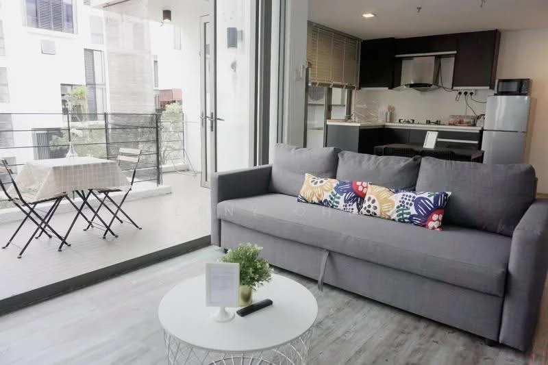 Living features: grey fabric sofa, decorative throw pillows with colorful patterns, round coffee table with white top, floor-to-ceiling windows, sliding glass door, laminate flooring, recessed downlights, wall-mounted TV, open layout to kitchen, area rug; style: modern; view: garden. Balcony features: metal bistro table, two folding chairs, outdoor flooring, railings; view: garden.