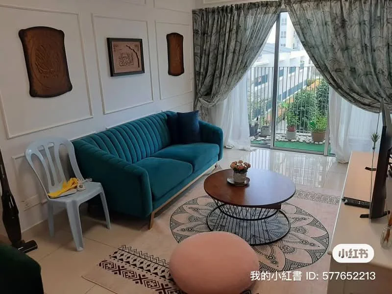 Living features: teal fabric sofa, round coffee table with wooden top, area rug with geometric pattern, floor-to-ceiling windows, sheer curtains, decorative wall panels, wall-mounted artwork, greenery visible outside, light-colored walls, laminate flooring; style: modern; view: garden.
