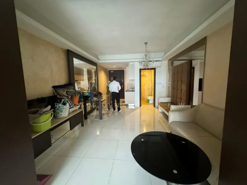 Living features: white painted walls, cream accent wall, polished tile flooring, chandelier, sofa in cream color, glass coffee table, large mirror, built-in cabinetry, decorative items on shelves, open layout, natural light from windows; style: modern.